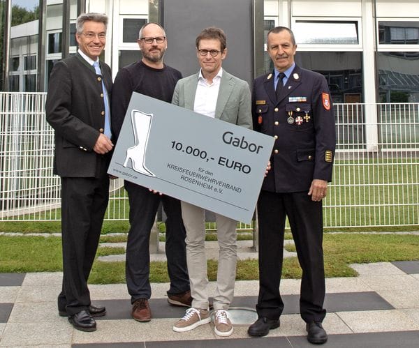 CEO Stefan Blöchinger (zweiter von rechts) übergibt den symbolischen Scheck an Landrat Otto Lederer (links), Christof Vornberger (zweiter von links) und Richard Schrank (rechts) vor der Gabor-Zentrale in Rosenheim.